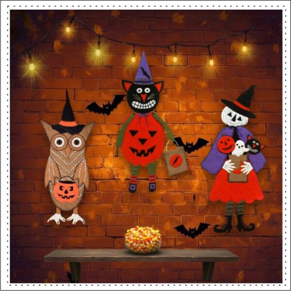Three Halloween wool felt characters in a Halloween setting with a shelf and a bowl of candy corn